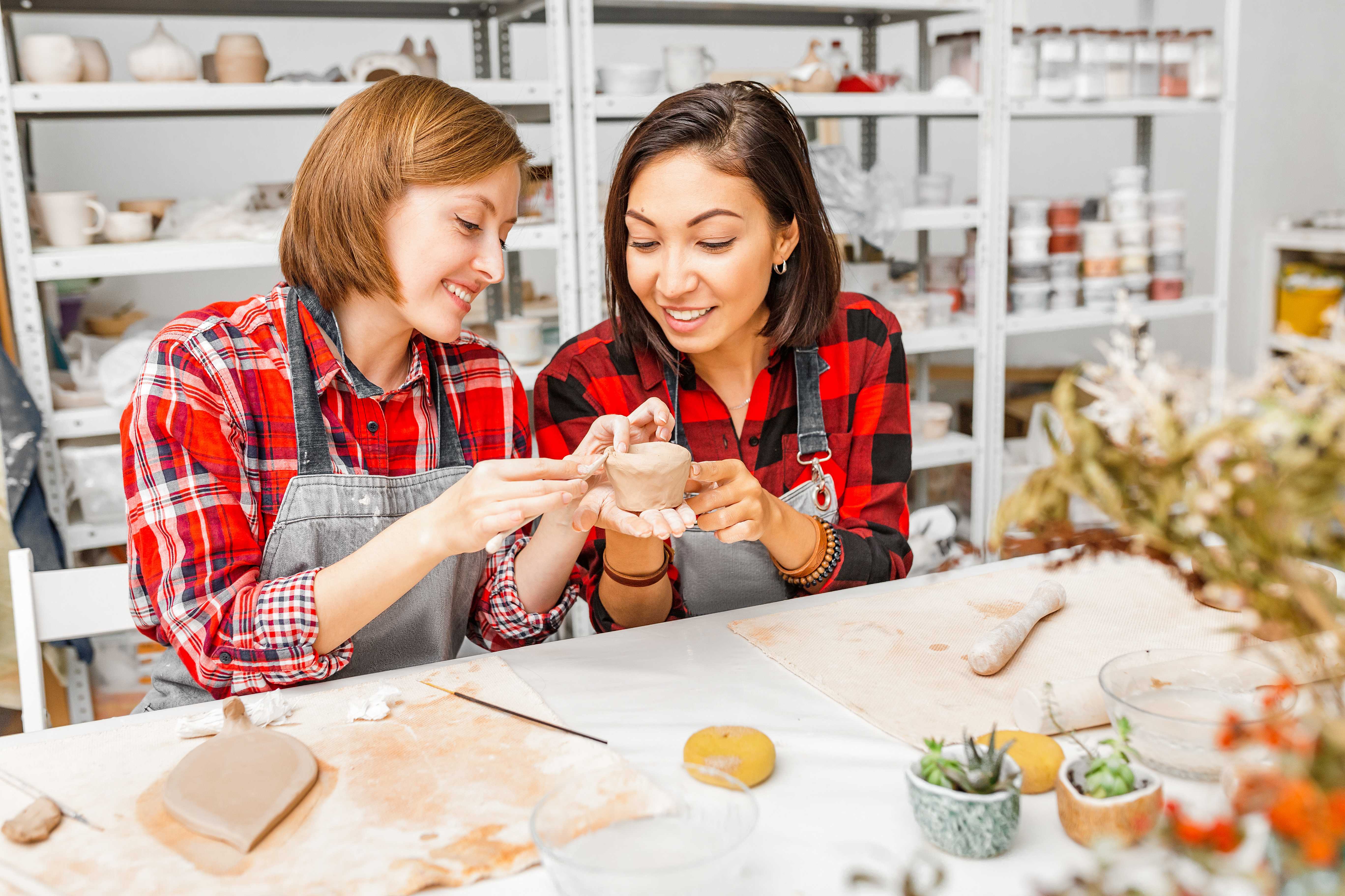 Two girls are taking a pottery class.