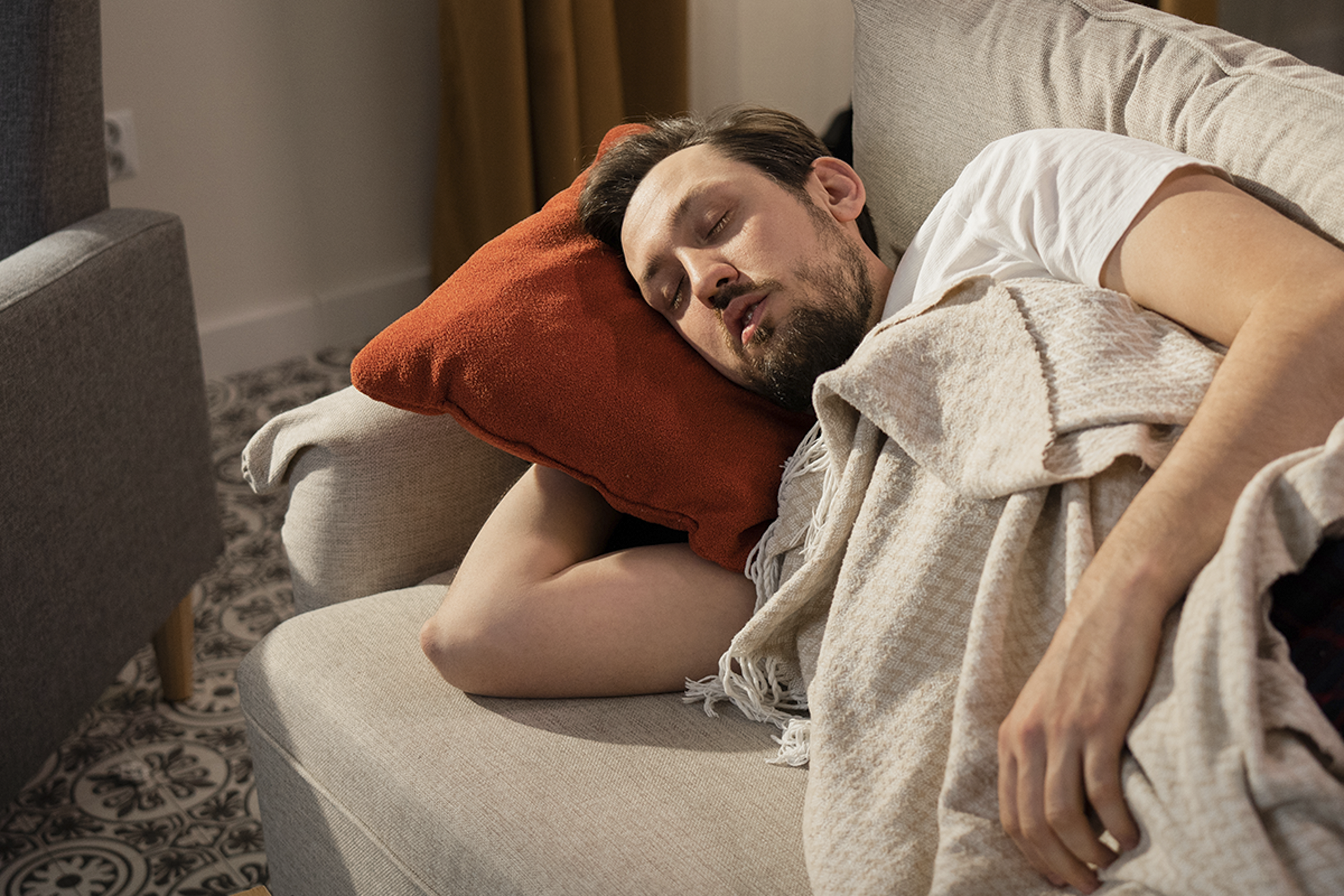 Ein Mann der auf einer Couch schläft.