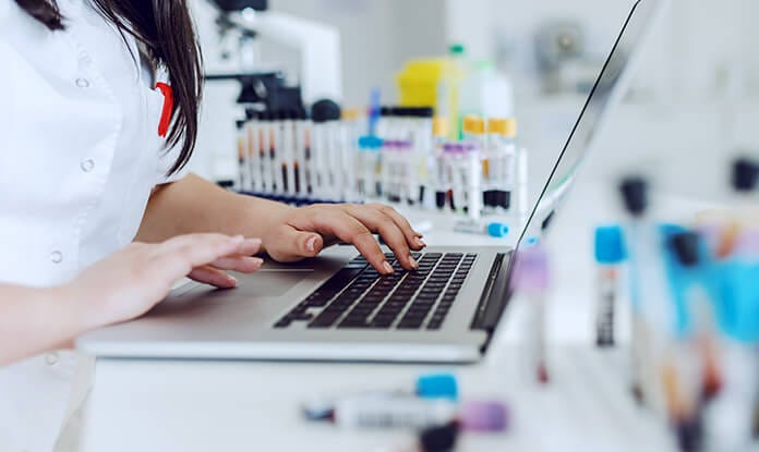 premium-versicherungsschutz-mitarbeiterin-im-labor-gibt-daten-ein-teaser.jpg