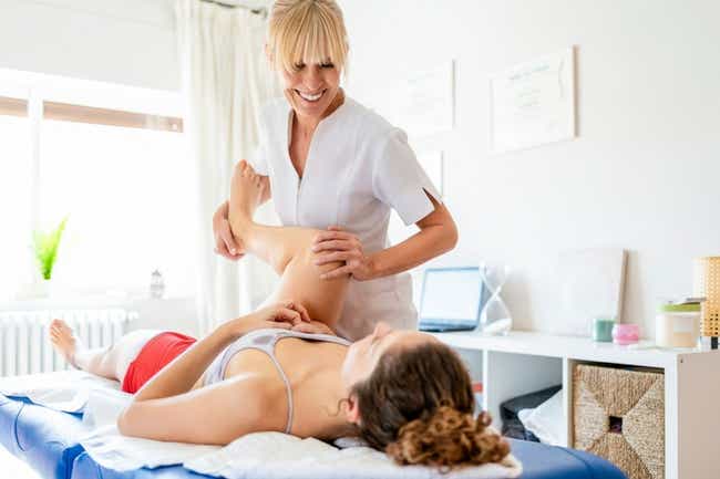 Osteopathin behandelt Patientin in einem Zimmer auf einer blauen Liege