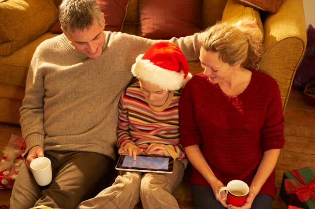 Familie mit Kind schauen Tablet