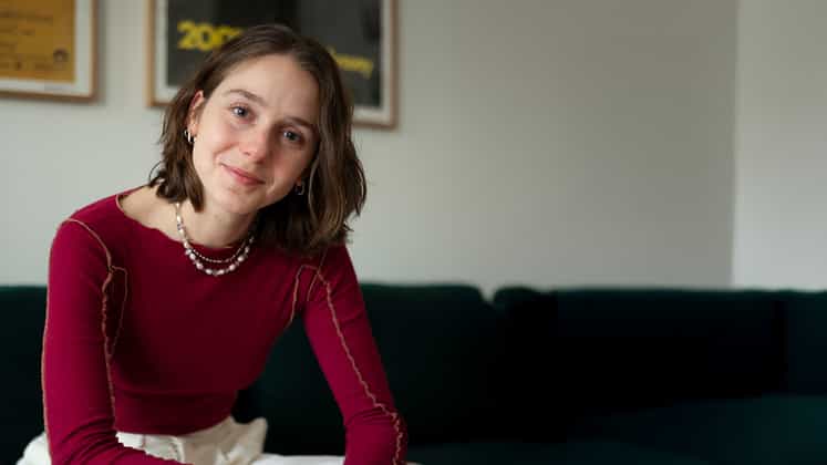 Eine junge Frau lächelt in die Kamera.